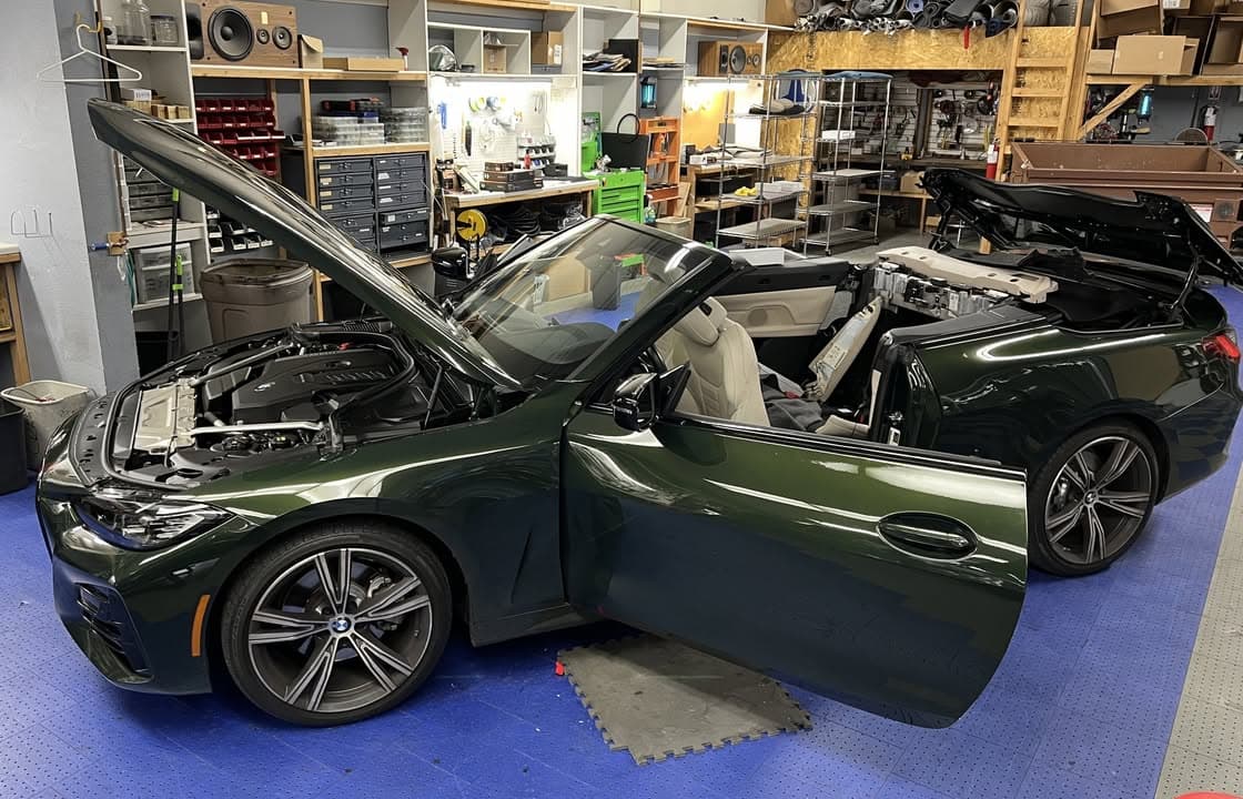 Green BMW 430i convertible in the Car Audio Innovations shop with its panels open for installation work