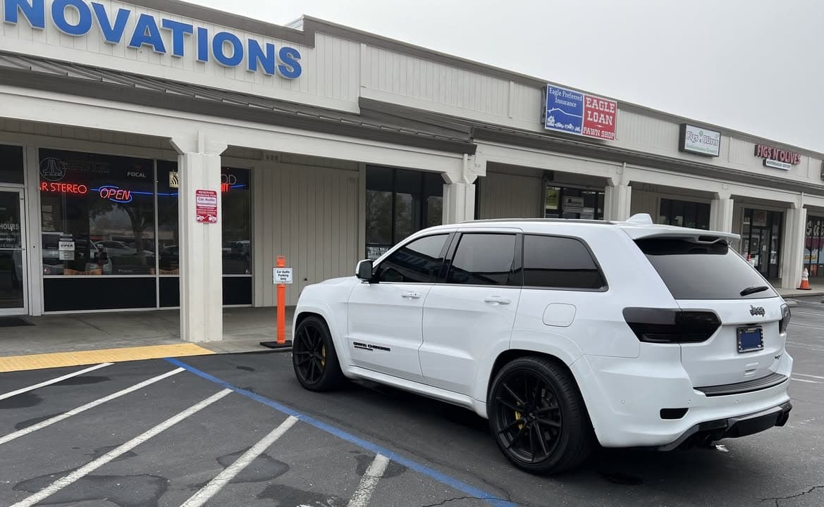 White Jeep Grand Cherokee Trackhawk outside the Car Audio Innovations storefront
